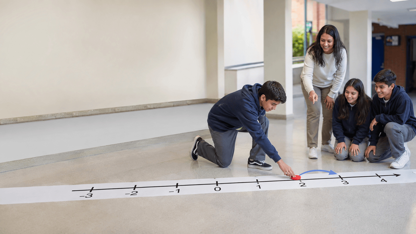 Docente y estudiantes practican desplazamientos en una recta numérica en el piso