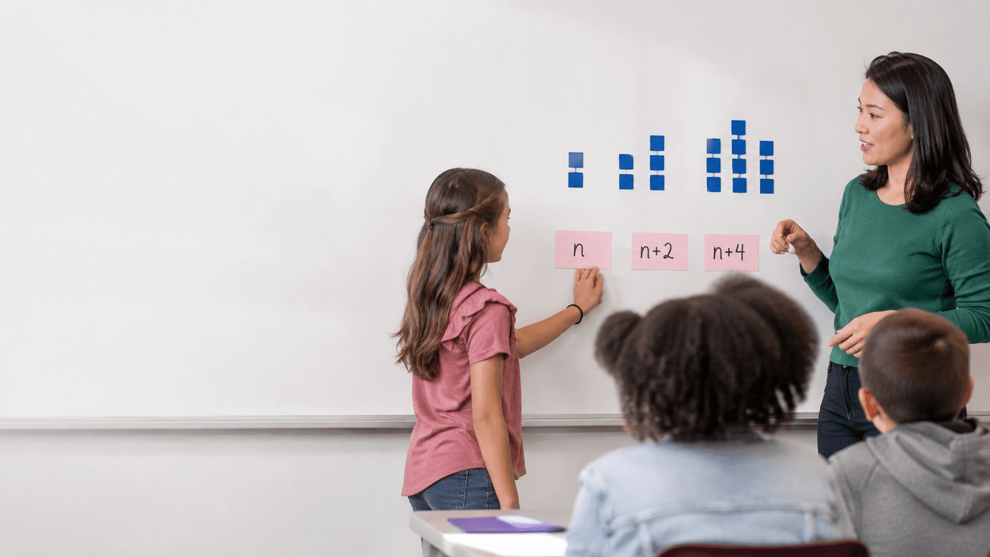 Estudiante escribe la generalización n, n+2, n+4 de un patrón en la pizarra junto a su docente