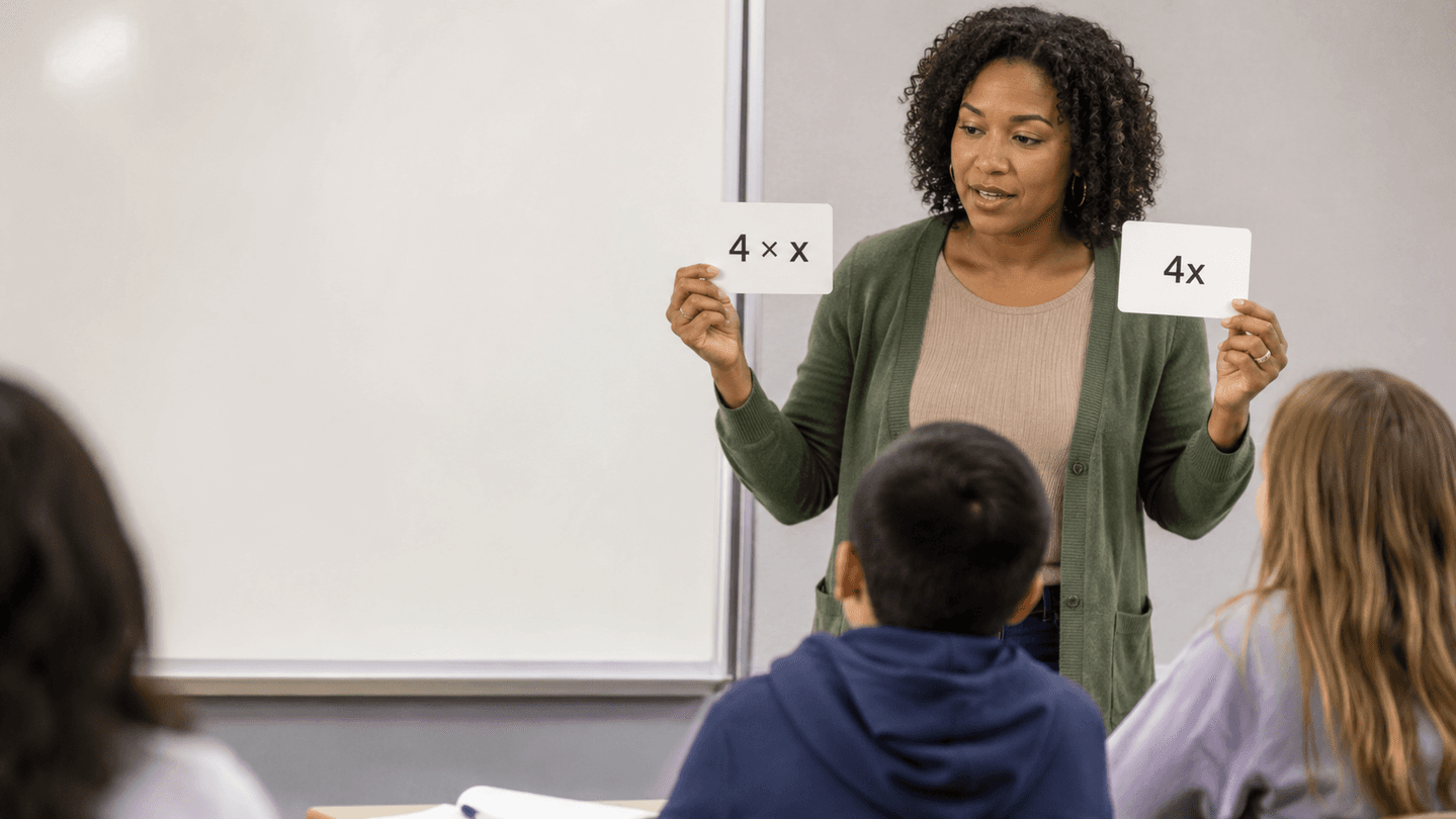 Docente muestra las tarjetas 4×x y 4x a sus estudiantes
